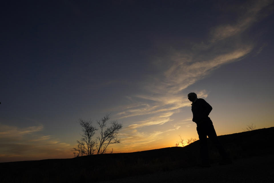 Rancher Randy Nunns watches sunset on the Monarch Ranch near Del Rio, Texas, Thursday, Feb. 16, 2023. Nunns and fellow landowners along the Devil's River argue that proposed wind turbines would kill birds, bats and disrupt monarch butterflies migrating to Mexico and impact ecotourism, a main source of income for many. (AP Photo/Eric Gay)