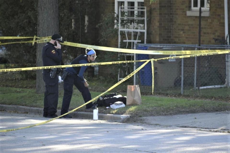 Kenosha Police officers look over evidence at the scene of a triple homicide that happened late Tuesday night in Kenosha, Wis., Wednesday, Oct. 20, 2021. Three people were killed and two others critically wounded in a shooting at a home in a southeastern Wisconsin city, and police said Wednesday they believe the shooter is among the dead.(Dan Truttschel/The Kenosha News via AP)