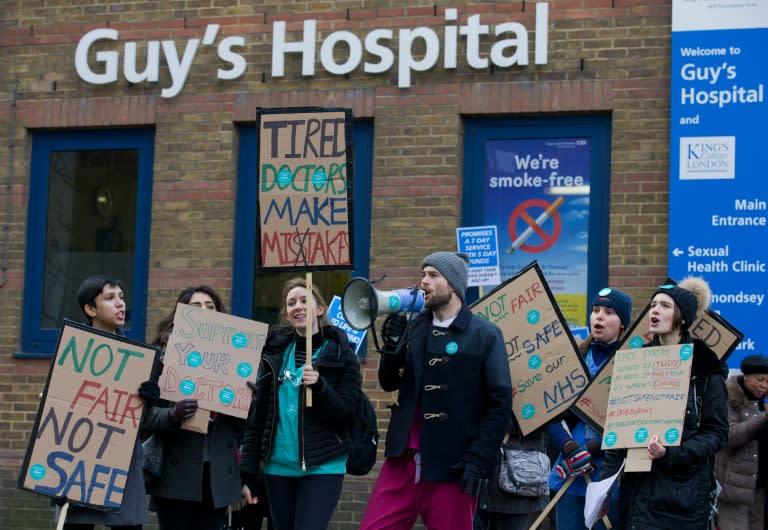 Junior doctors shout slogans and hold placards as they protest outside Guy's Hospital in London during a 24-hour strike over pay and conditions on February 10, 2016