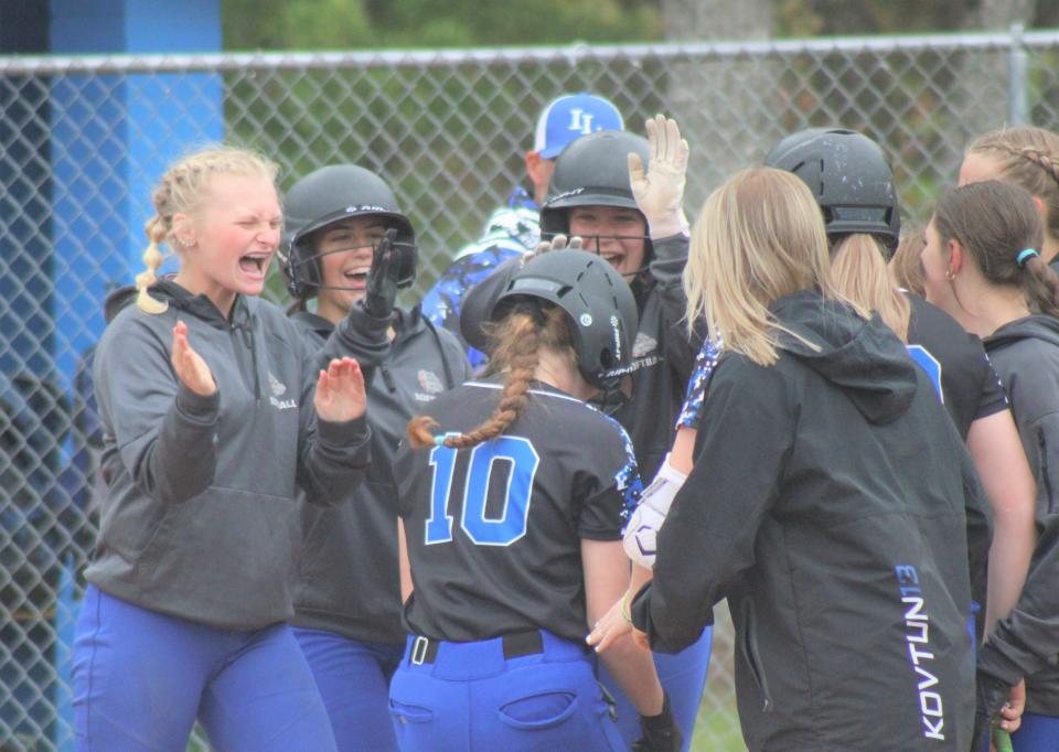 Inland Lakes softball players celebrate with junior Brooklyn LaBrecque, who blasted a home run during game two of a doubleheader against Gaylord St. Mary at home on Wednesday.