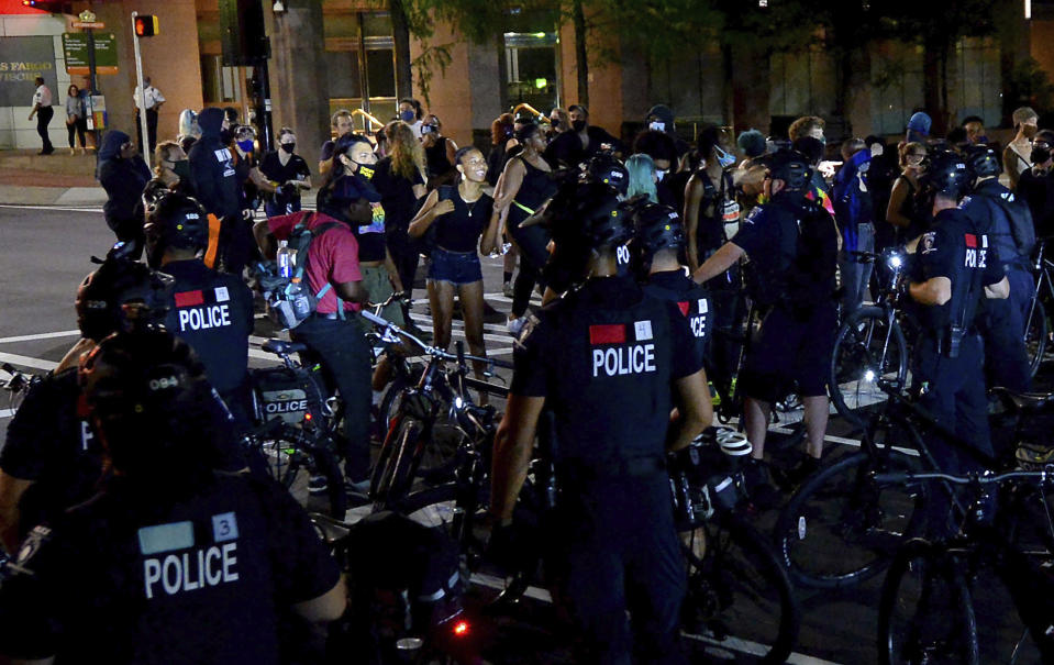 Protesters express themselves to Charlotte Mecklenburg Police bike officers at the intersection of Martin Luther King Jr. Blvd. and College Street in uptown Charlotte, N.C., on Friday, Aug. 21, 2020. (Jeff Siner/The Charlotte Observer via AP)