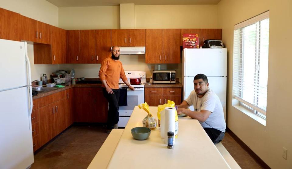 Marcos Gonzalez Rios and Rogaciano Sonchez Tapia talk in the kitchen of their unit at Ringold, a farmworker housing complex in Mesa, WA, owned by Wafla.