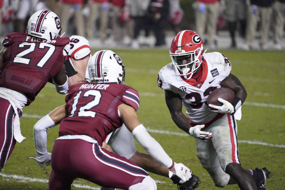 Georgia running back Daijun Edwards (33) carries the ball against South Carolina defensive back Joey Hunter (12) during the second half of an NCAA college football game Saturday, Nov. 28, 2020, in Columbia, S.C. (AP Photo/Sean Rayford)