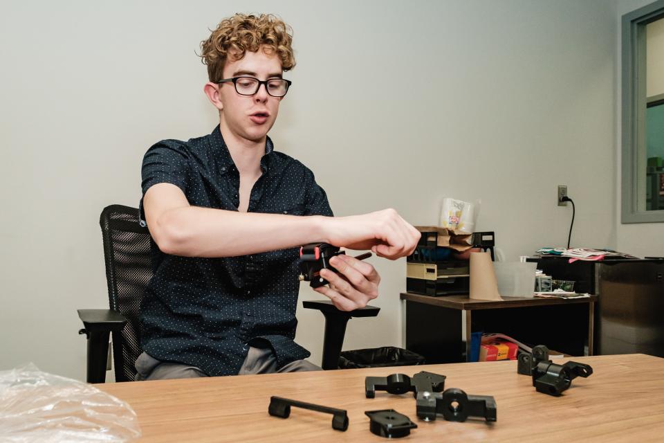 Aiden Springer, a graduating senior from Dover High School, talks about a 3D-printed adaptive device he created to help a fifth grader to play a stringed instrument.