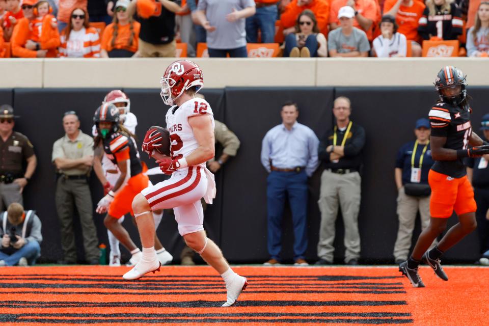 OU receiver Drake Stoops (12) catches a touchdown pass Saturday during a 27-24 loss at OSU in Stillwater.