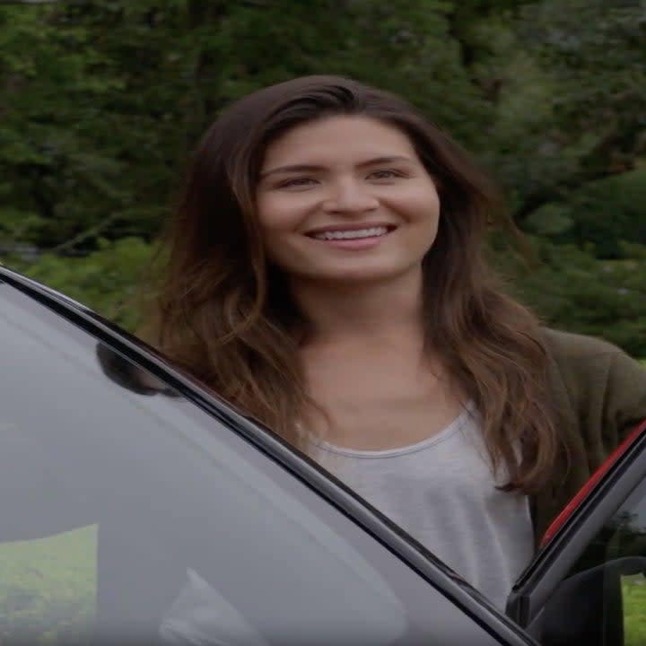 A woman smiles at someone off-camera.