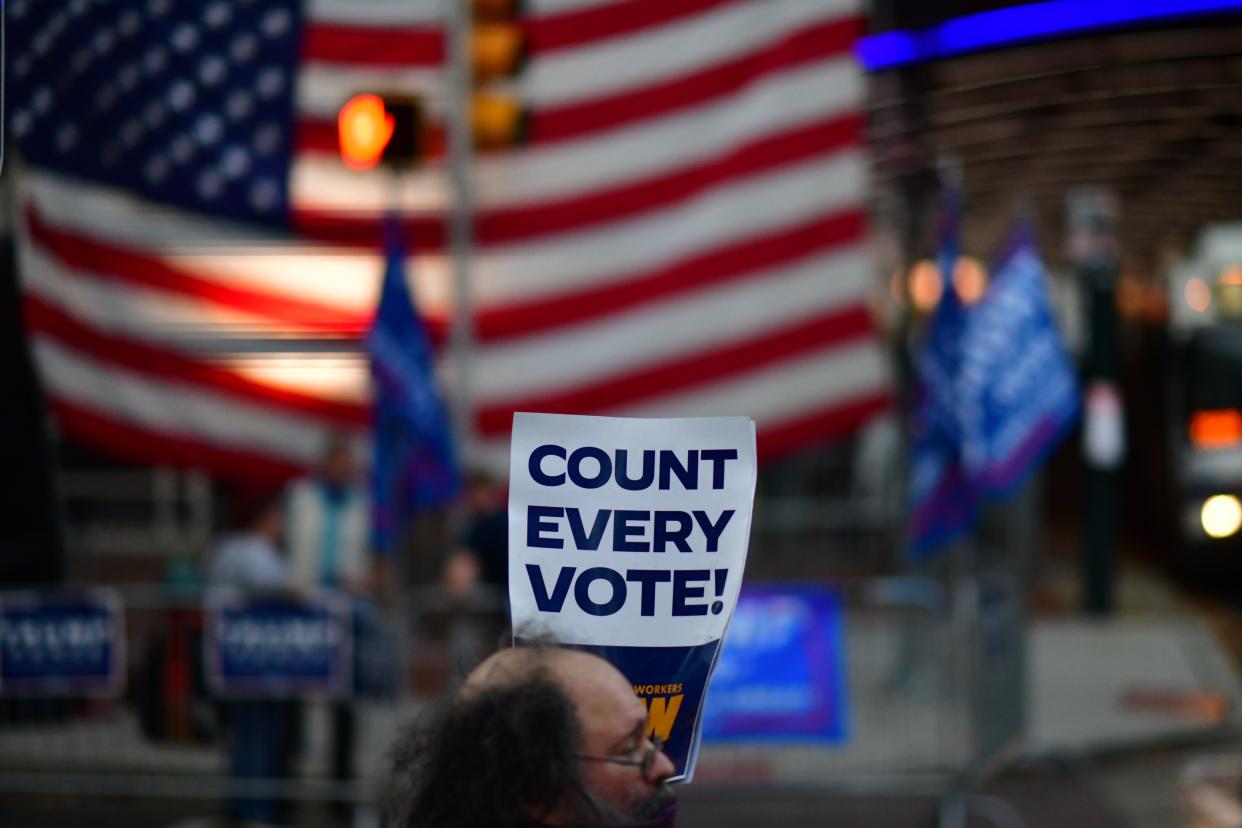 <p>A protester stands outside the Pennsylvania Convention Center on Sunday as the Trump campaign assembled their legal team</p> (Getty Images)