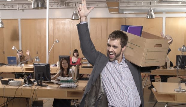 Man holding box with arm in air, smiling