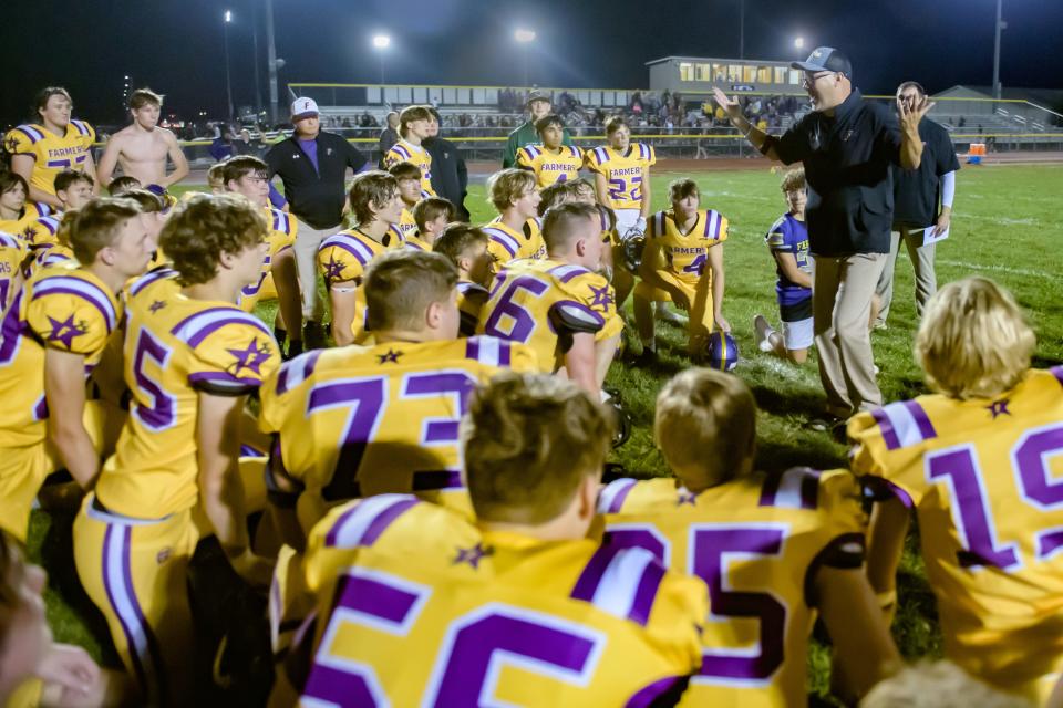 The Farmington Farmers gather around their coach Toby Vallas after their victory over Elmwood Brimfield in a varsity football game Friday, Sept. 22, 2023 in Farmington. The farmers defeated their rival Trojans 30-26.