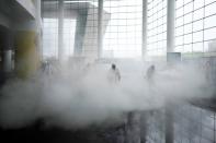 Volunteers from the Blue Sky Rescue team disinfect at the Qintai Grand Theatre in Wuhan