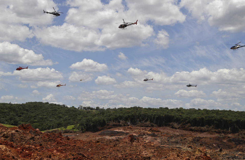 FILE - In this Feb. 1, 2019, file photo, helicopters hover over an iron ore mining complex to release thousands of flower petals paying homage to the dozens of victims killed and scores of missing after a mining dam collapsed there a week earlier, in Brumadinho, Brazil. The Danish pension fund for academics began selling off its stake in a Brazilian mining company, Vale, after two of the company's tailings dams collapsed, killing hundreds of people. So did Sweden's national pension. The main goal of institutional investors is to maximize returns. But now, more than ever, many are considering issues such as climate change and human rights. (AP Photo/Andre Penner, File)