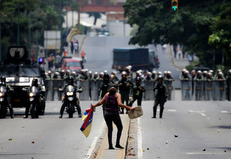 A demonstrator gestures while facing riot police during a rally against Venezuela's President Nicolas Maduro in Caracas, Venezuela, April 20, 2017. REUTERS/Carlos Garcia Rawlins
