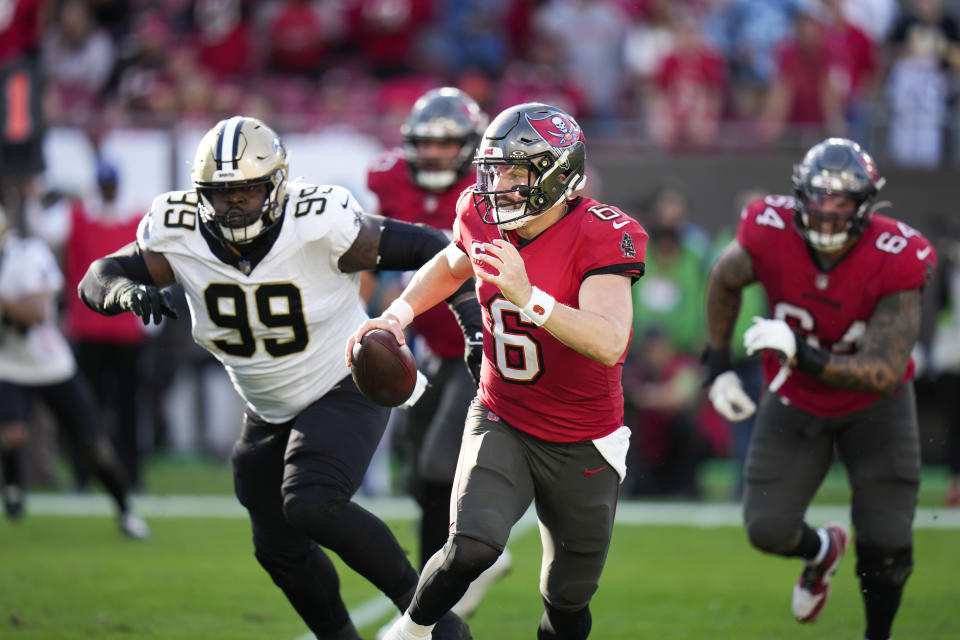 Tampa Bay Buccaneers quarterback Baker Mayfield (6) scrambles under pressure from New Orleans Saints defensive tackle Khalen Saunders (99) in the second half of an NFL football game in Tampa, Fla., Sunday, Dec. 31, 2023. (AP Photo/Chris O'Meara)