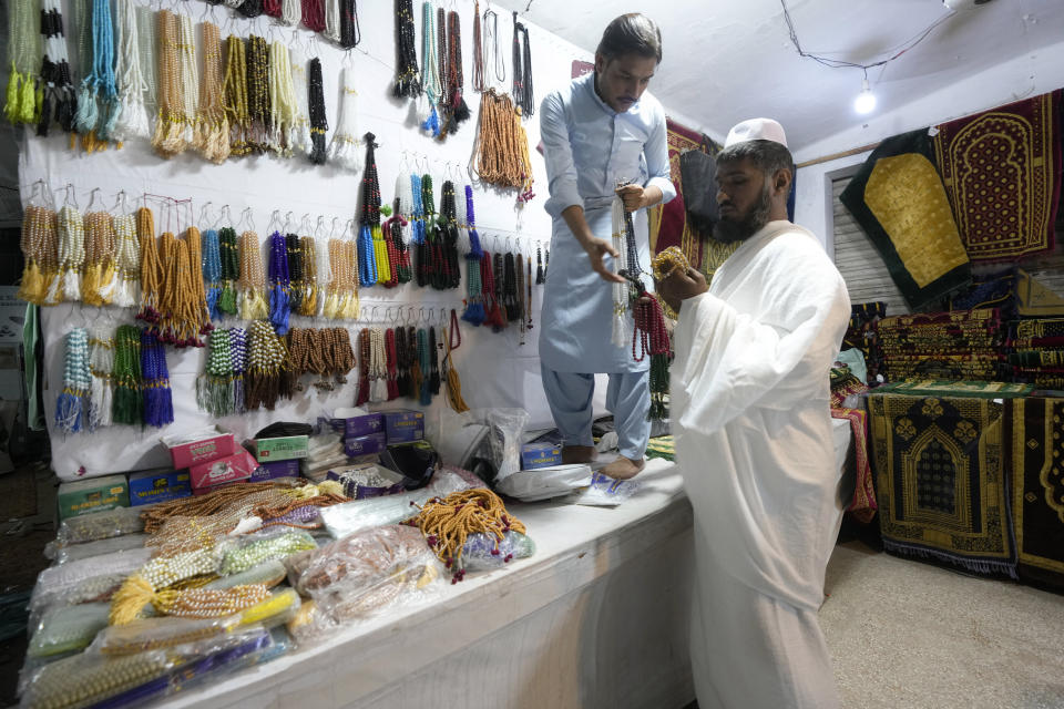 A pilgrim looks at prayer beads in a shop offering discount rates at a Hajj training center in Karachi, Pakistan, Monday, June 19, 2023. Saudi Arabia is hosting its biggest Hajj pilgrimage in three years, starting Monday. But for many pilgrims and others who couldn't make it, global inflation and economic crises made it more of a strain to carry out Islam's spiritual trip of a lifetime. (AP Photo/Fareed Khan)