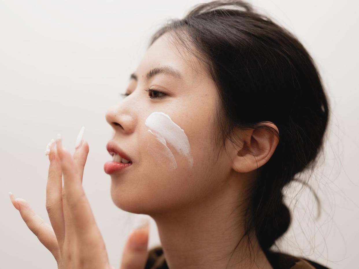 woman applying moisturizer