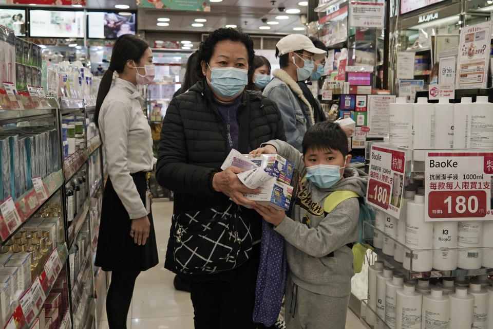 A woman a boy purchase face masks in Hong Kong, Saturday, Feb, 1, 2020. China’s death toll from a new virus has risen over 250 and a World Health Organization official says other governments need to prepare for“domestic outbreak control” if the disease spreads. (AP Photo/Kin Cheung)