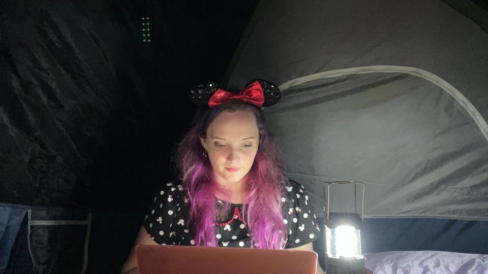 jenna clark with laptop in dark tent