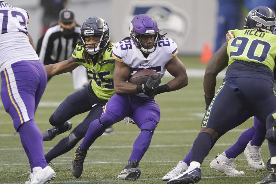 Minnesota Vikings' Alexander Mattison (25) is chased by Seattle Seahawks' Ryan Neal during the first half of an NFL football game, Sunday, Oct. 11, 2020, in Seattle. (AP Photo/Ted S. Warren)