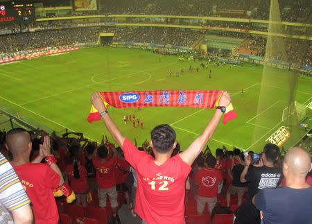 Fans watch a local soccer match between Shanghai SIPG Football Club and Shanghai Greenland Shenhua Football Club, at Hongkou Football Stadium, Shanghai, China, July 17, 2016. Picture taken July 17, 2016. REUTERS/David Stanway