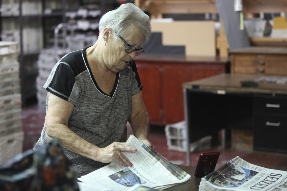 Barb Creamer, who works in the distribution operation for the Marion County Record, goes through copies of its latest edition, Wednesday, Aug. 16, 2023, in Marion, Kan. Local police raided the newspaper's offices and the home of its publisher on Aug. 11, 2023, and that hindered publication of its latest issue. (AP Photo/John Hanna)