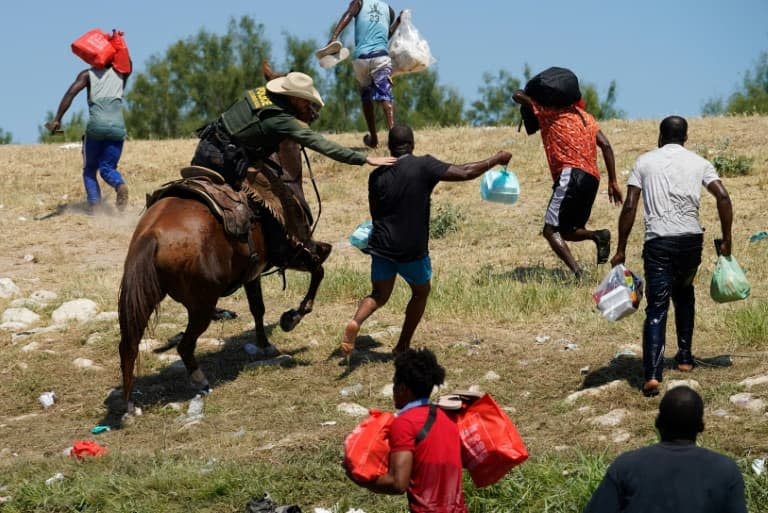 Un garde-frontières américain à cheval tente de stopper un migrant haïtien d'entrer dans un campement sur les rives du Rio Grande, à Del Rio, au Texas, le 19 septembre 2021 - PAUL RATJE © 2019 AFP