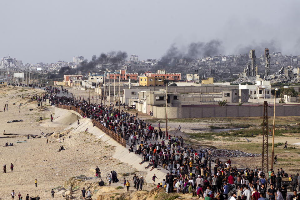 Palestinians are waiting for aid trucks to cross in central Gaza Strip on Sunday, May 19, 2024. (AP Photo/Abdel Kareem Hana)