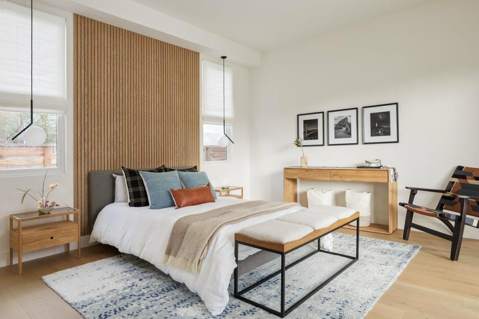 A dramatic wall treatment behind the bed makes a statement in a guest bedroom