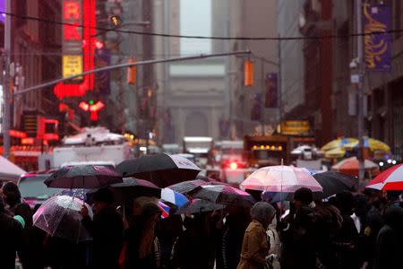 People walk through as rain falls in Times Square Manhattan, New York City, U.S., December 29, 2016. REUTERS/Andrew Kelly