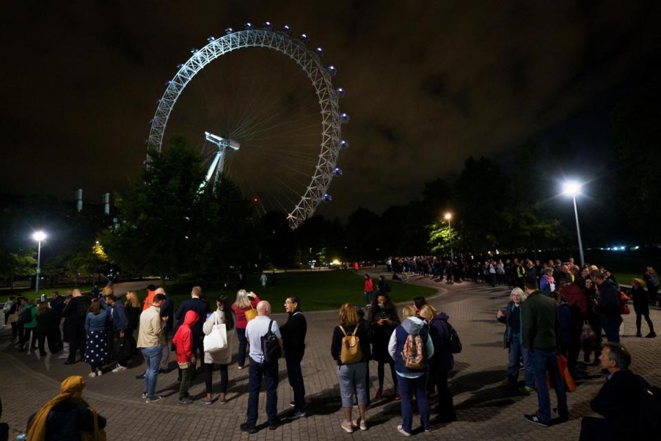 Members of the public stand in the queue on the South Bank in London adjacent to the London Eye, as they wait to view Queen Elizabeth II lying in state ahead of her funeral (PA)