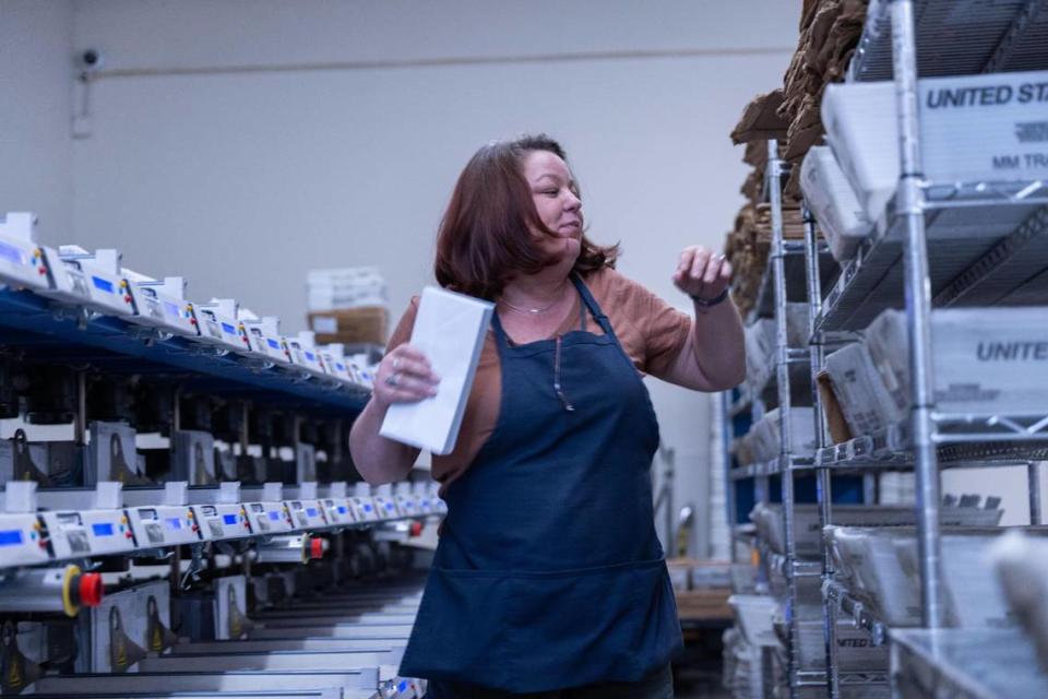 Mailing machine supervisor Chelsea Jacobs places paychecks for California state workers in boxes to be mailed on Aug. 24.