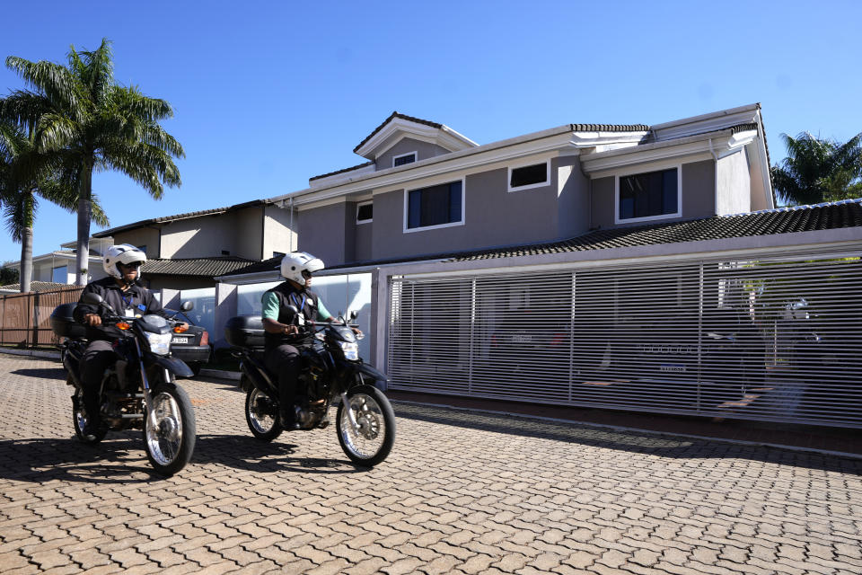 Condo security guards pass in front of the home of former Brazilian President Jair Bolsonaro after Federal Police agents carried out a search and seizure warrant in Brasilia, Brazil, Wednesday, May 3, 2023. When asked about the search of Bolsonaro’s home in Brasilia, the Federal Police press office gave a statement saying officers were carrying out searches and arrests related to the introduction of fraudulent data related to the COVID-19 vaccine into the nation’s health system. (AP Photo/Eraldo Peres)