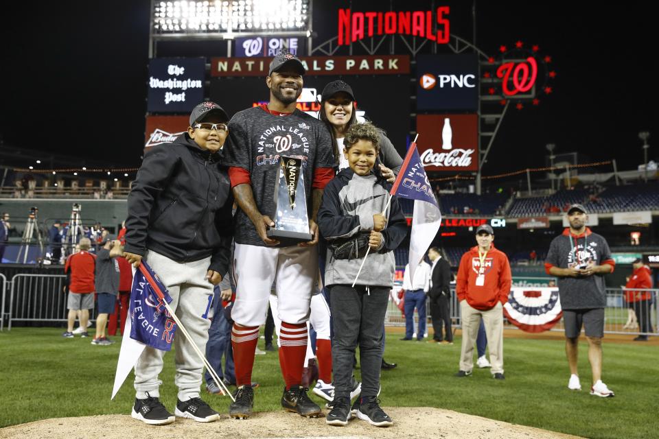 Washington Nationals' Howie Kendrick holds his MVP trophy as he celebrates with his family after Game 4 of the baseball National League Championship Series against the St. Louis Cardinals Tuesday, Oct. 15, 2019, in Washington. The Nationals won 7-4 to win the series 4-0. (AP Photo/Patrick Semansky)