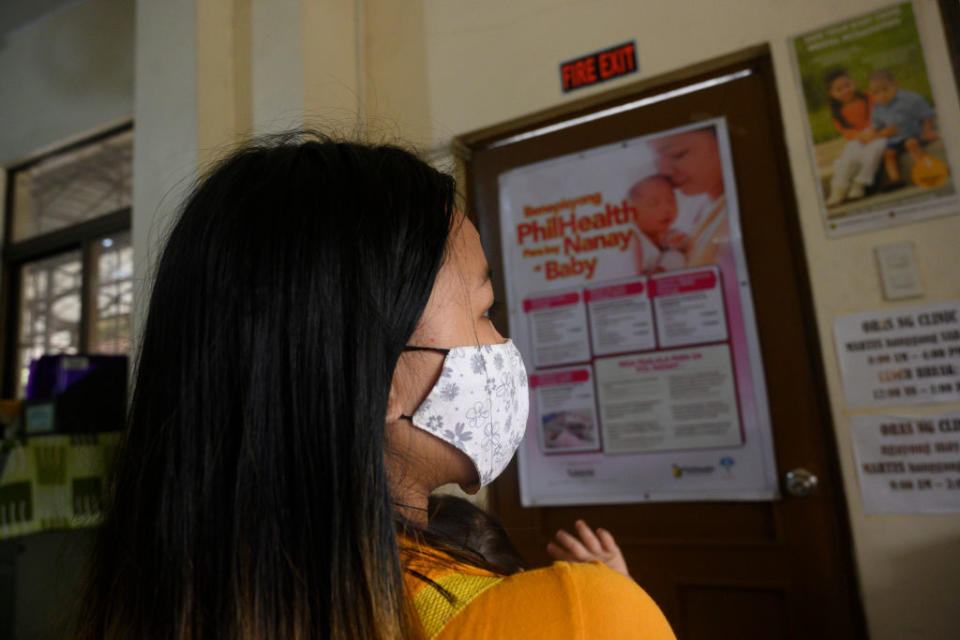 In this photo taken on December 2, 2020, Donna Valdez, 15, whose name AFP has changed to protect her identity, arrives with her child at a health center in Manila.<span class="copyright">TED ALJIBE/AFP via Getty Images</span>