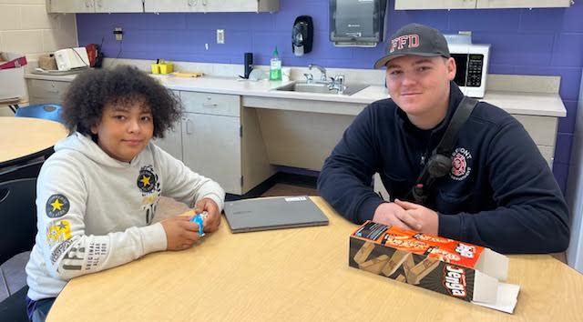 Sixth grader Jeremiah Clark meets with Fremont City Firefighter Garrett Schneider.