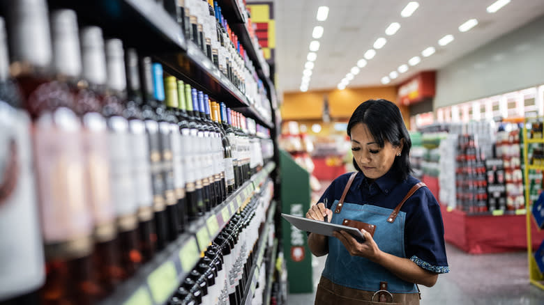 Liquor store clerk with bottles