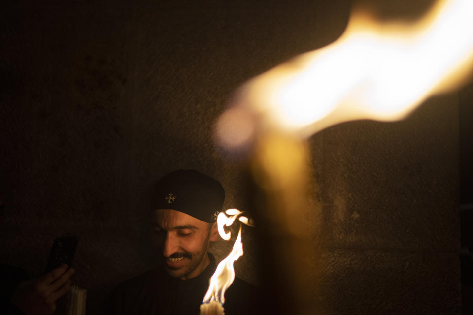 A Christian Orthodox pilgrim holds up a candle during the Holy Fire ceremony at the Church of the Holy Sepulchre, where many Christians believe Jesus was crucified, buried and rose from the dead, in the Old City of Jerusalem. Saturday, May 4, 2024. In the annual ceremony that has been observed for over a millennium, a flame taken from Jesus' tomb is used to light the candles of fervent believers of Christian Orthodox communities near and far. The devout believe the origin of the flame is a miracle and is shrouded in mystery. (AP Photo/Leo Correa)