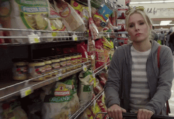 Kristin Bell grocery shopping and dropping a bunch of chips into her cart