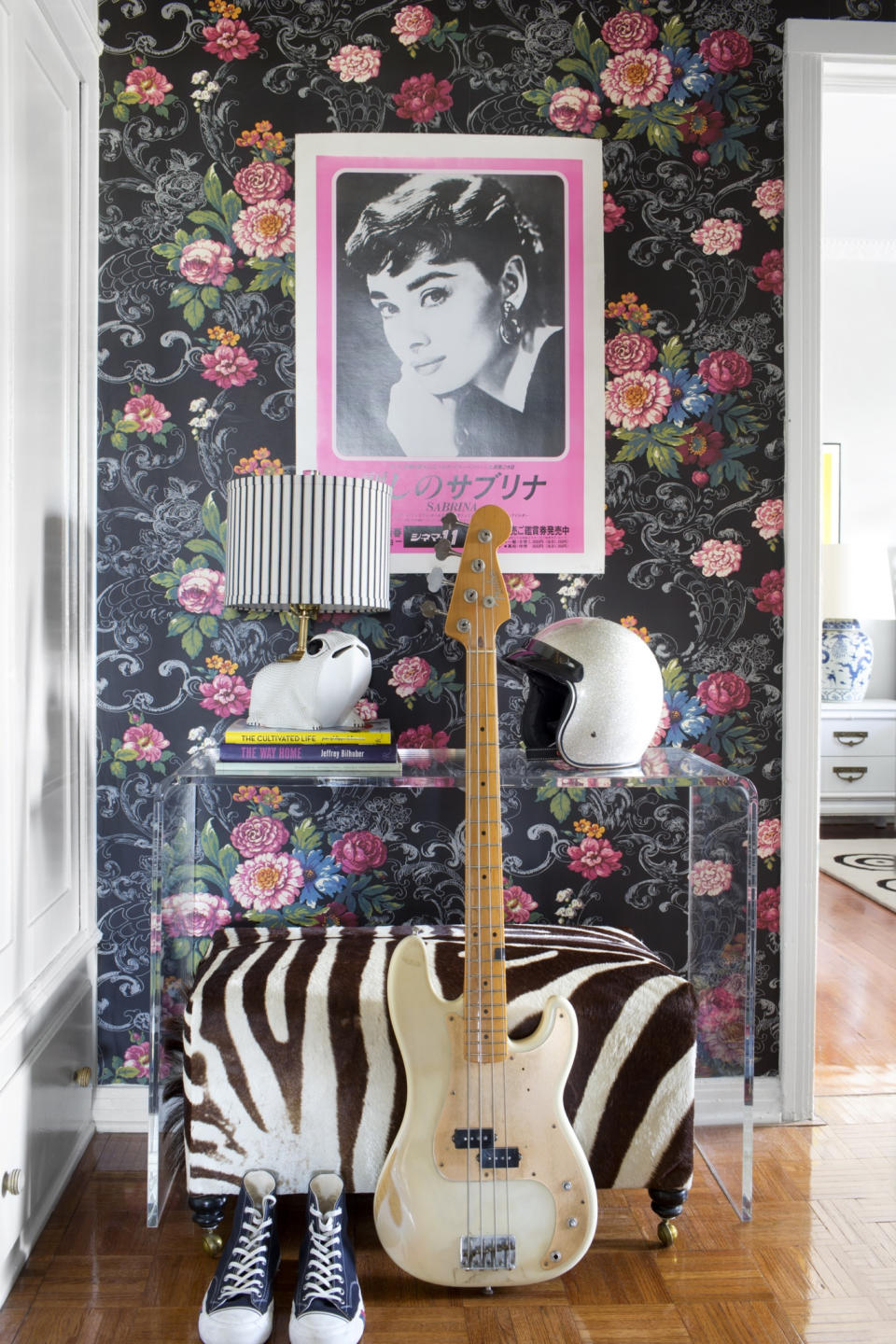In this photo provided by courtesy of Burnham Design, traditional floral wallpaper is contrasted with modern furniture and unexpected accessories like a bike helmet and a vintage Japanese poster for the movie "Sabrina," to create a fresh and edgy look designed by Betsy Burnham and Max Humphrey of Burnham Design, in this residence in Los Angeles. (AP Photo/Courtesy Burnham Design, Sarah Dorio)