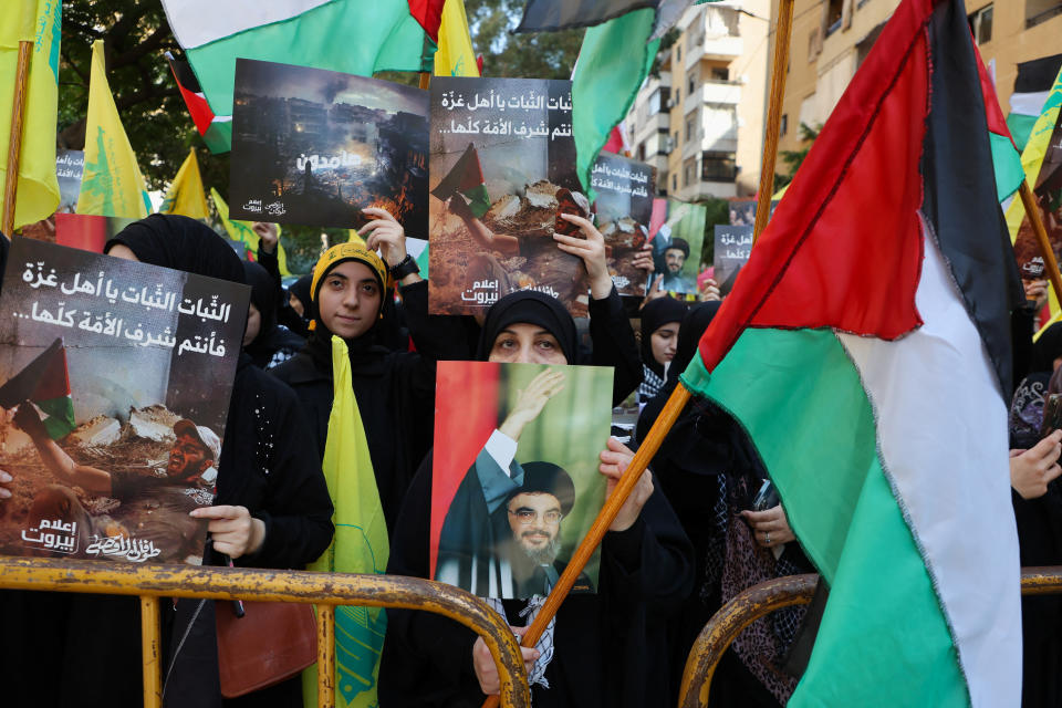 真主黨支持者舉著橫幅和旗幟。（路透社資料照）