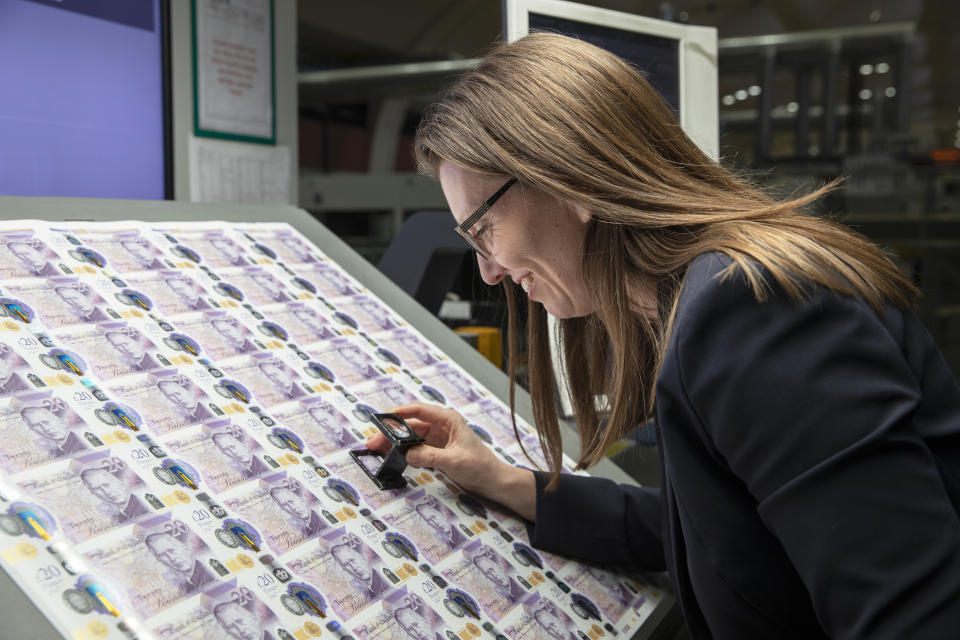 Sarah John, chief cashier, examining the new bank notes. (Bank of England)