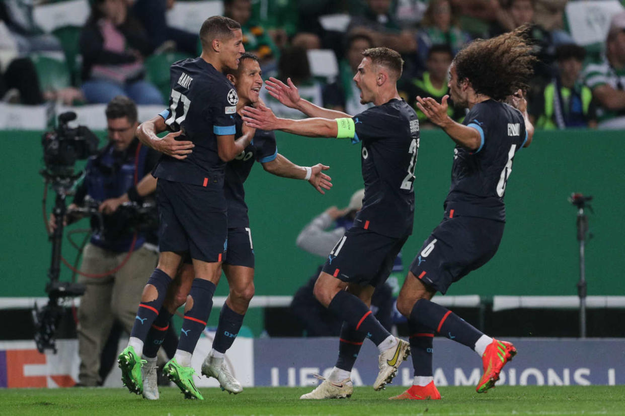 Marseille's Chilean forward Alexis Sanchez (2nd-L) celebrates with teammates after scoring his team's second goal during the UEFA Champions League 1st round, group D, football match between Sporting CP and Olympique de Marseille at the Jose Alvalade stadium in Lisbon on October 12, 2022. (Photo by CARLOS COSTA / AFP)