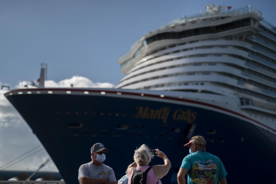 Tourists take pictures after exiting Carnival's Mardi Gras cruise ship, docked in the bay of San Juan, Puerto Rico, Tuesday, Aug. 3, 2021, marking the first time a cruise ship visits the U.S. territory since the COVID-19 pandemic began. (AP Photo/Carlos Giusti)