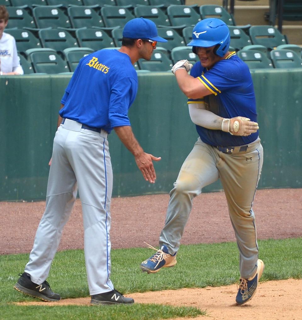 Clear Spring's Logan Helser follows through on a high five with third-base coach Brandon Glazer as he heads to the plate after hitting a three-run homer in the third inning of the Blazers' 11-3 win for the Class 1A state title.