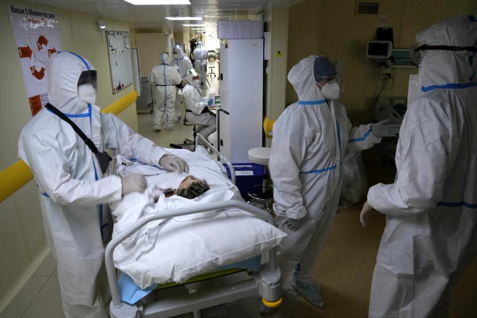 Medics wearing special suits to protect against coronavirus prepare to move a patient with coronavirus at an ICU at the Moscow City Clinical Hospital 52, in Moscow, Russia, Tuesday, Oct. 19, 2021. Russia hit another daily record of coronavirus deaths Tuesday as rapidly surging infection rates raised pressure on the country's health care system and prompted the government to suggest declaring a nonworking week.(AP Photo/Alexander Zemlianichenko)