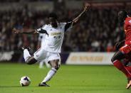 Swansea City's Wilfried Bony (L) shoots at goal during their English Premier League soccer match against Liverpool at the Liberty Stadium, in Swansea, Wales September 16, 2013.