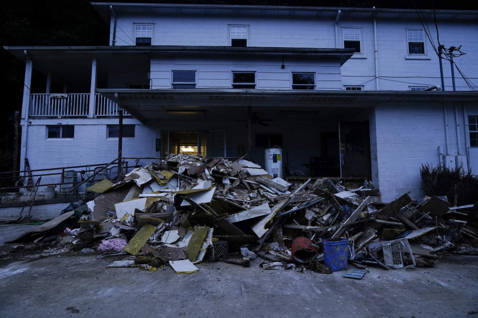 Piles of debris and mud covering a road are seen after massive flooding on Friday, Aug. 5, 2022, in Lost Creek, Ky. (AP Photo/Brynn Anderson)