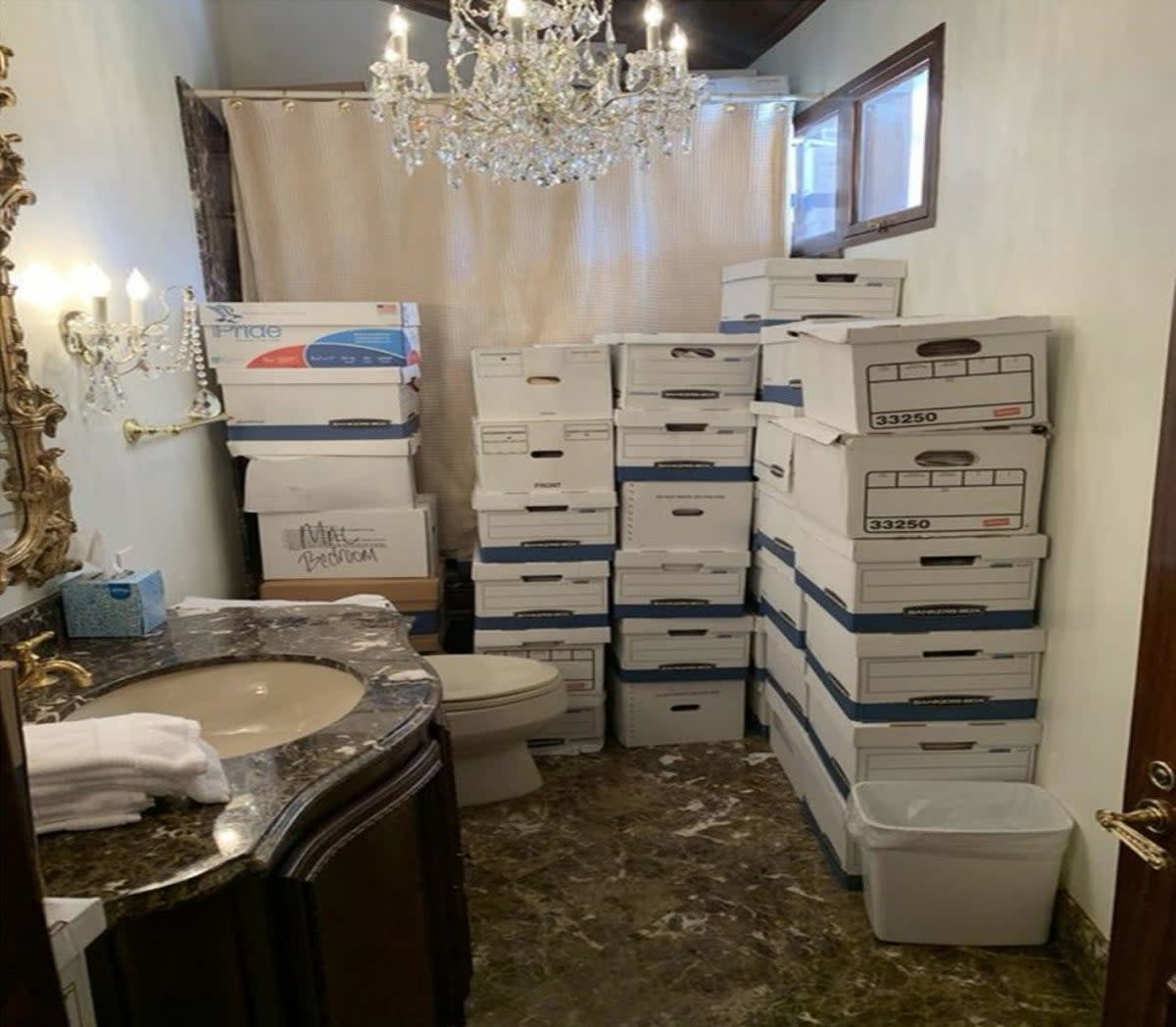 Towers of boxes containing classified material in a bathroom underneath a chandelier (US Justice Department)