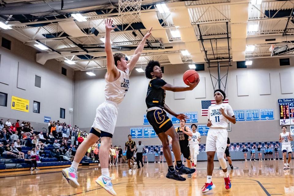 Hickman's Jordan Richardson (4) shoots the reverse layup as Tolton's Justin Boyer (3) defends during the Trailblazers' 82-58 win over the Kewpies on Jan. 12 at Tolton High School.