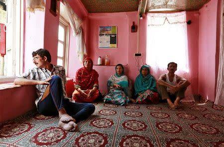 Members of a family watch television in their home in Srinagar as the city remains under curfew following weeks of violence in Kashmir, August 21, 2016. REUTERS/Cathal McNaughton