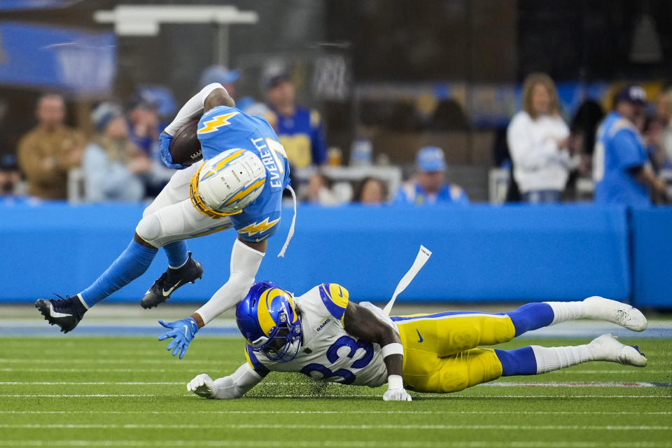 Los Angeles Chargers tight end Gerald Everett (7) tumbles after he was tackled by Los Angeles Rams safety Nick Scott (33) during the second half of an NFL football game Sunday, Jan. 1, 2023, in Inglewood, Calif. (AP Photo/Marcio Jose Sanchez)